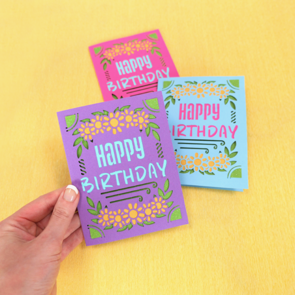 Handmade happy birthday cards in various colors with a bright yellow background